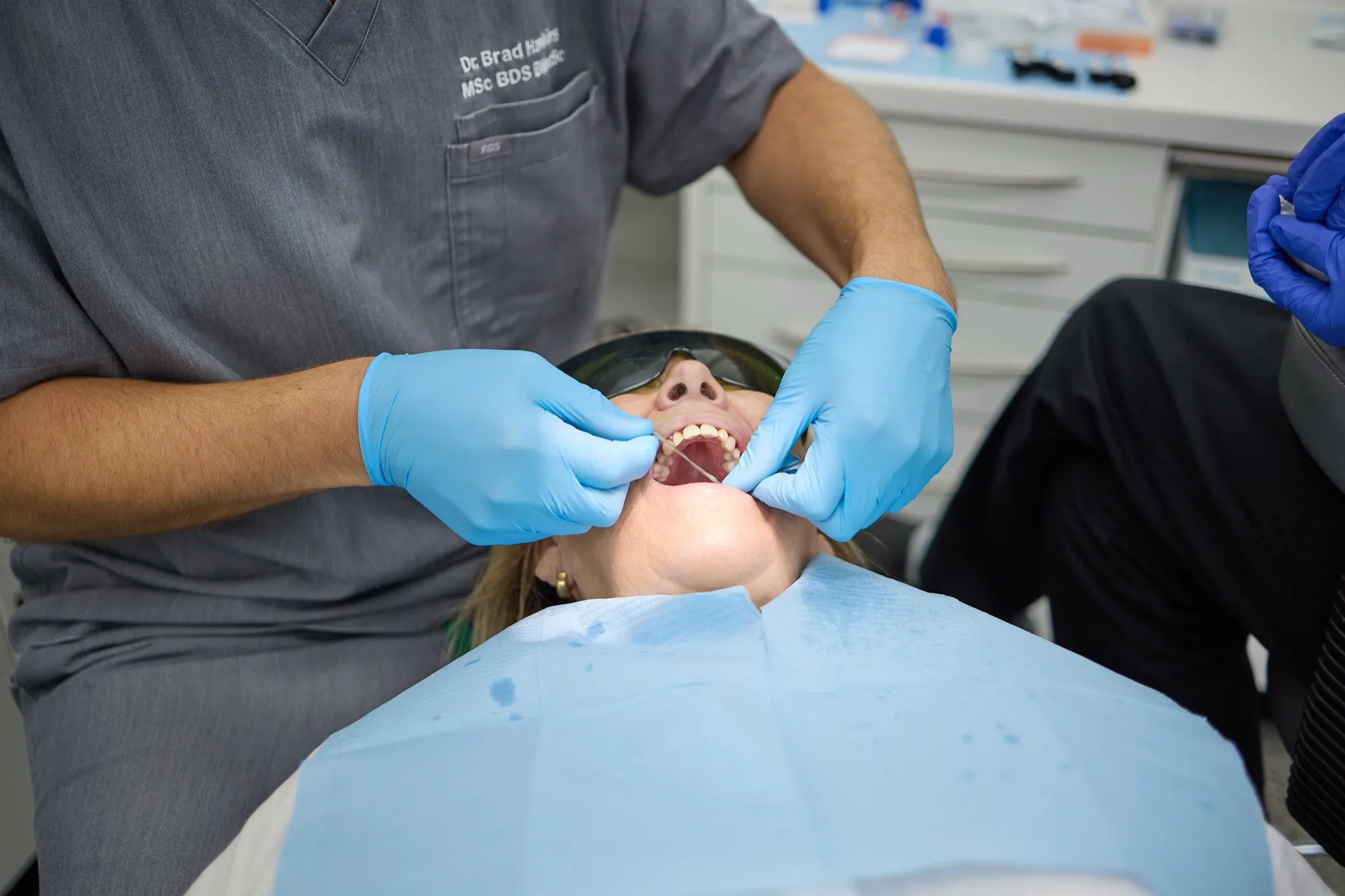 Dr Brad Hawkins examining a patient's upper teeth, retracting the lip to see the gum line