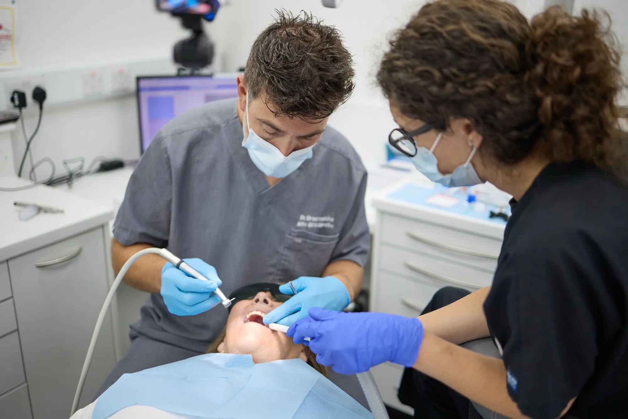 Dr Brad Hawkins treating a patient with a nurse assisting chairside