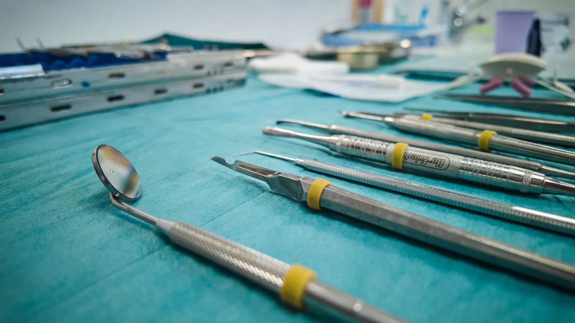 Close-up of dental instruments on a sterile drape, mirror in the foreground