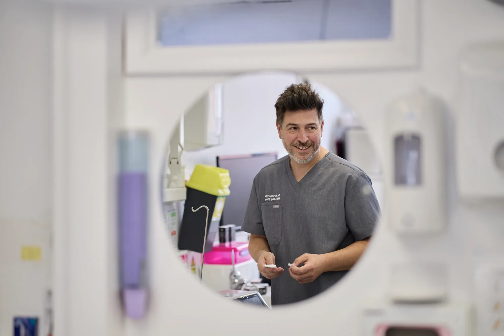 Dr Brad Hawkins at the surgery, reflected in a wall mirror