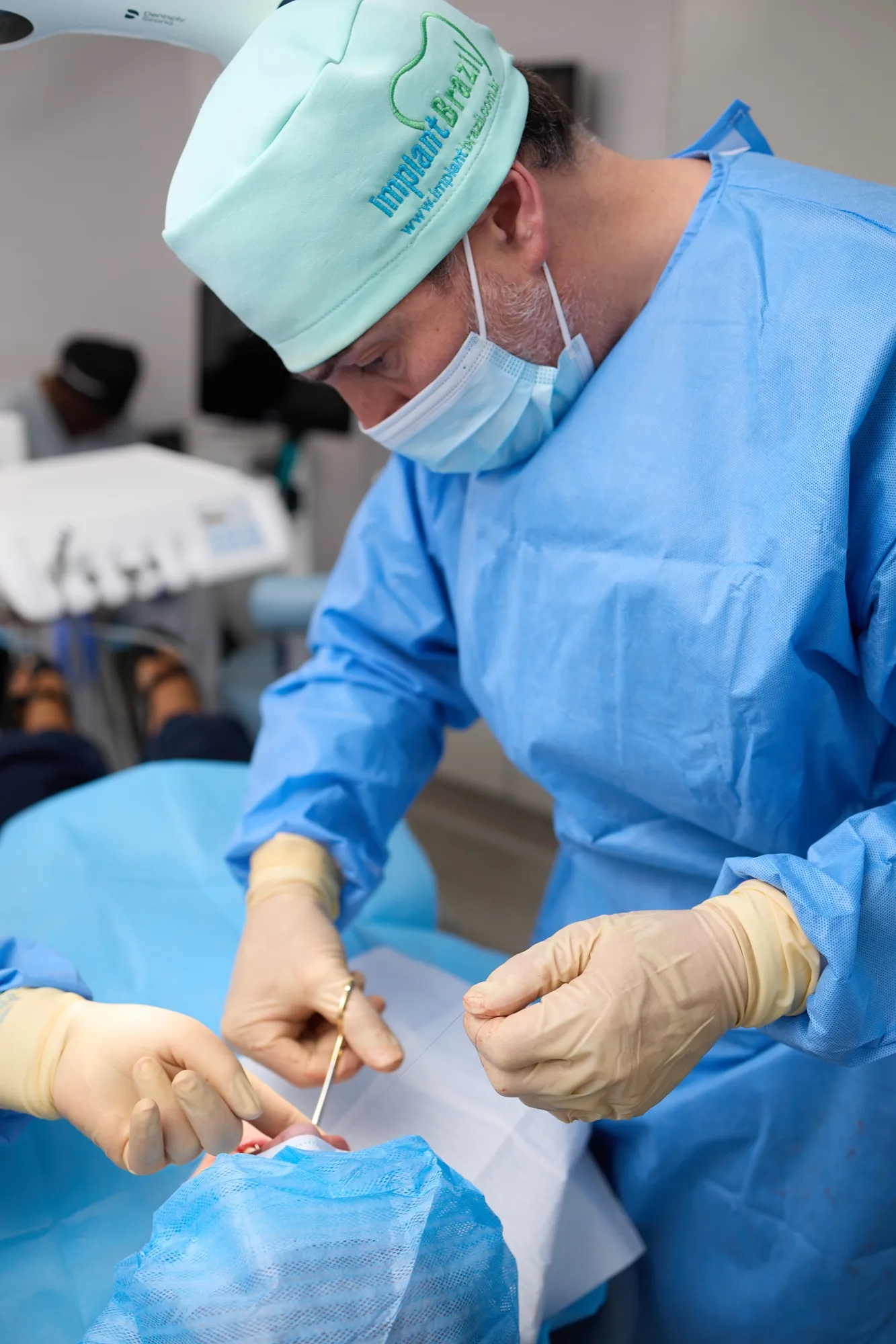 Dr Brad Hawkins placing dental implants, an assistant supporting the surgical field